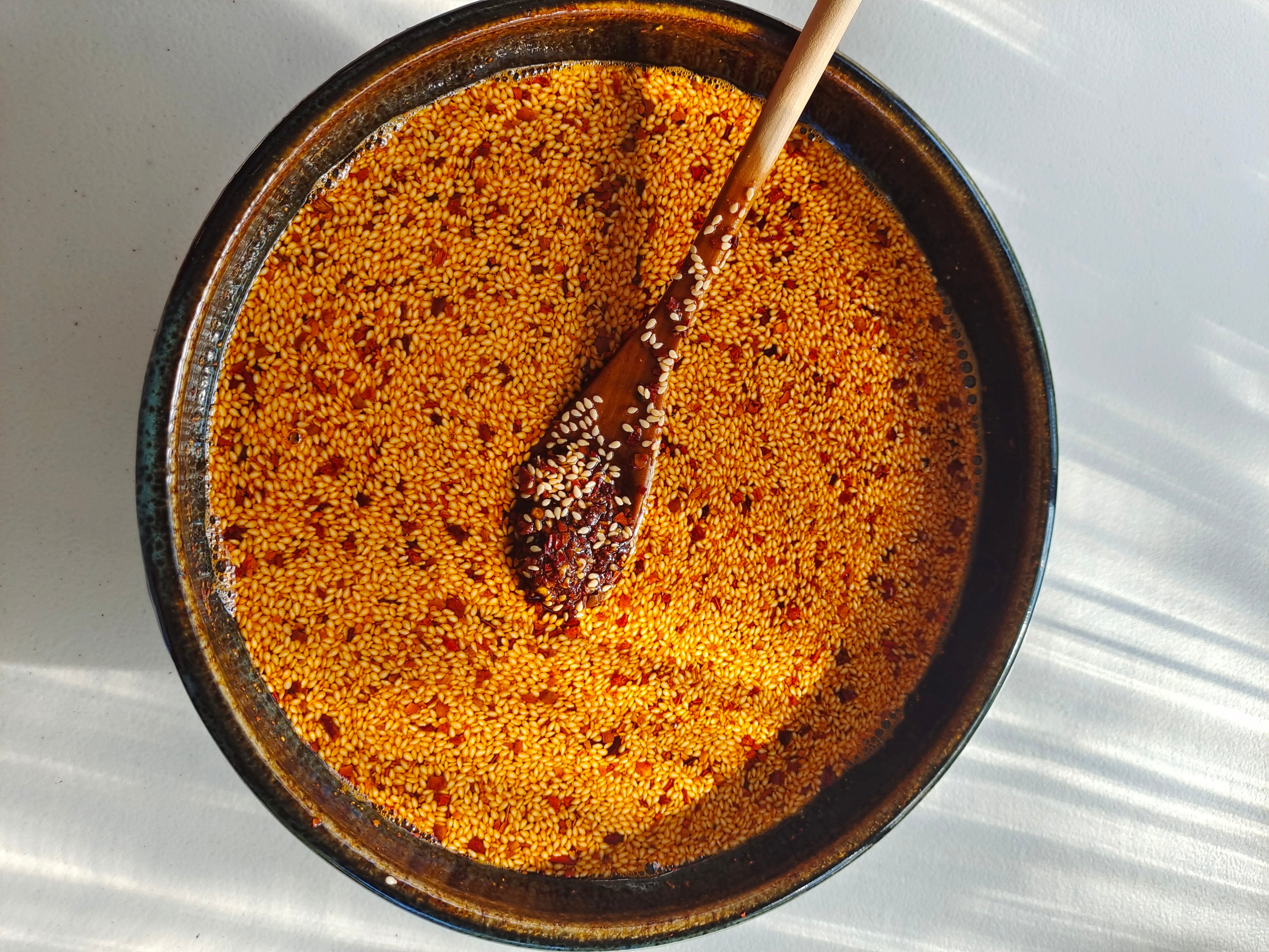 Photo showing freshly made chilli oil with sesame seeds floating on the surface.